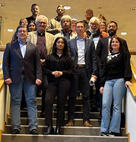 Roshani Thanapalasingham mit einer großen Gruppe von Personen auf einer Treppe